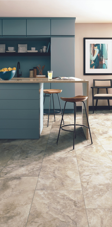 A kitchen with a bar stool and large kitchen tiles